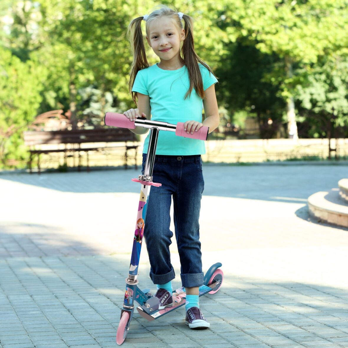 Small girl riding on scooter in park