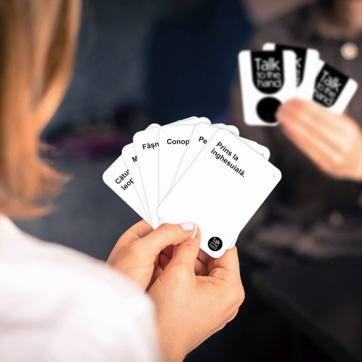 Friends are playing cards together at home. Woman is holding car